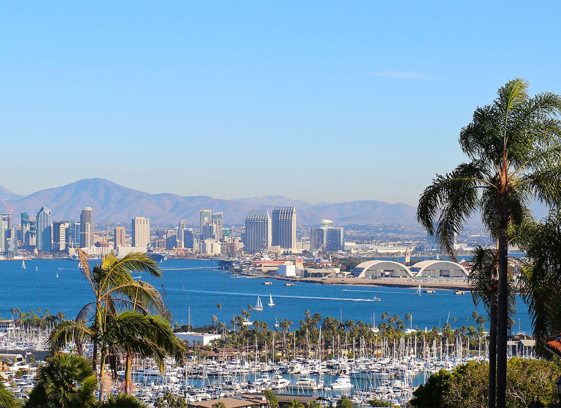 San Diego, CA - View of Downtown San Diego California Buildings by the Water with Mountains in the Distance on a Beautiful Day